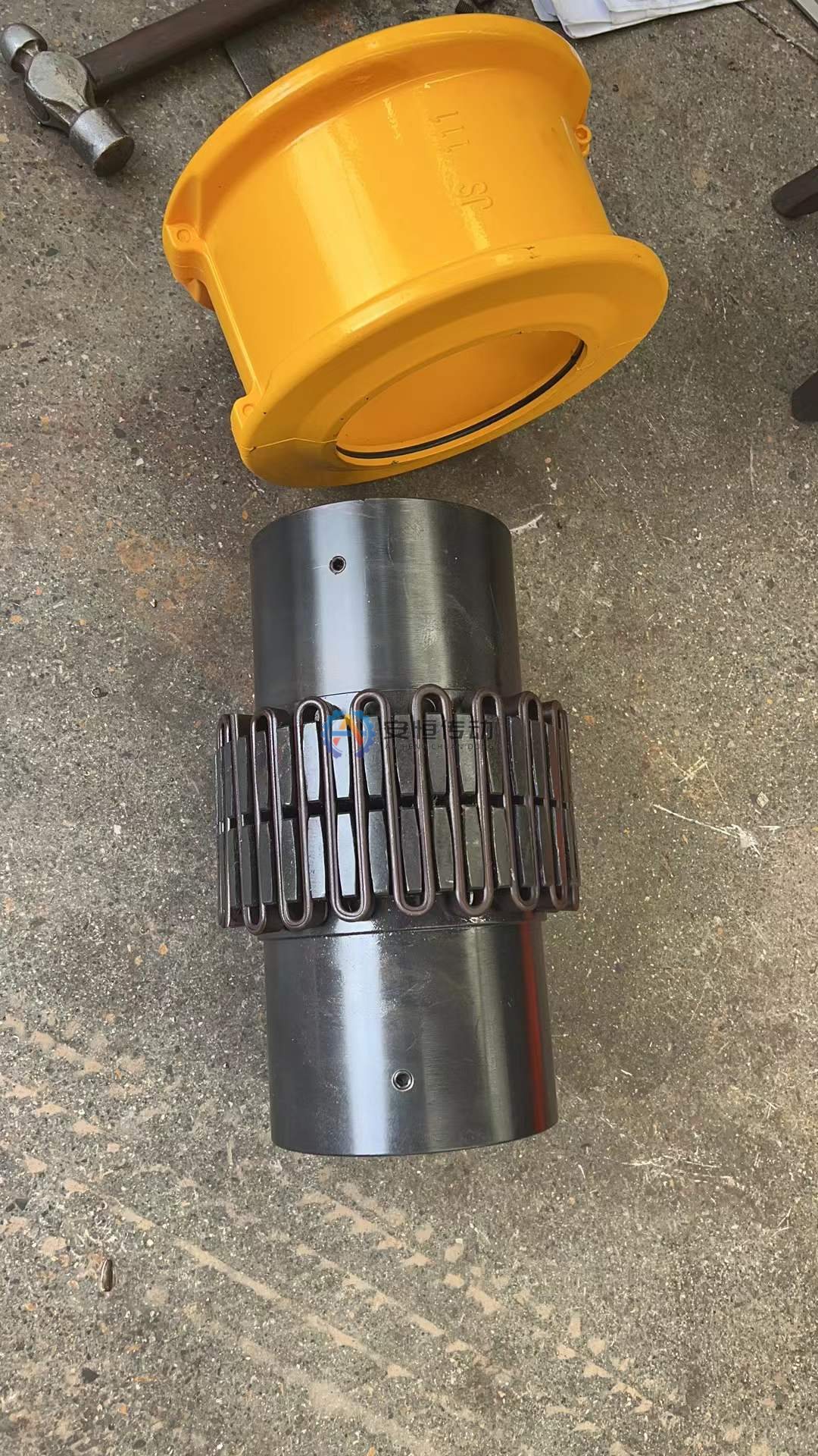 Broken grid spring and worn hub teeth from a ball mill drive grid coupling, laid out in order for fracture inspection